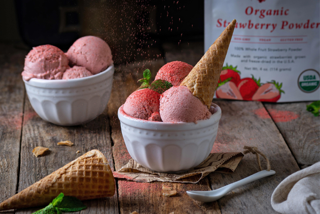Two bowls of strawberry powder ice cream being dusted with strawberry powder