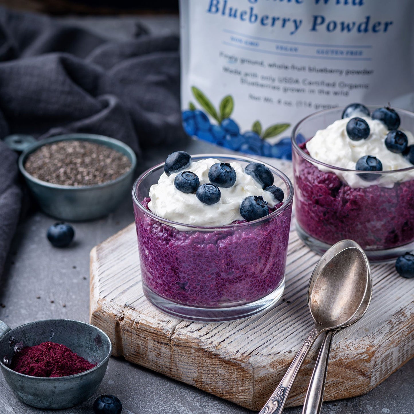 Wild Blueberry Powder Chia Seed Pudding topped with wild blueberries set on a rustic table