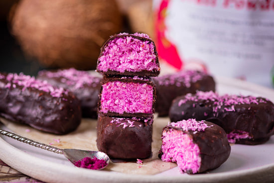 Homemade dragon fruit powder bounty bars cut open and stacked into a pile.