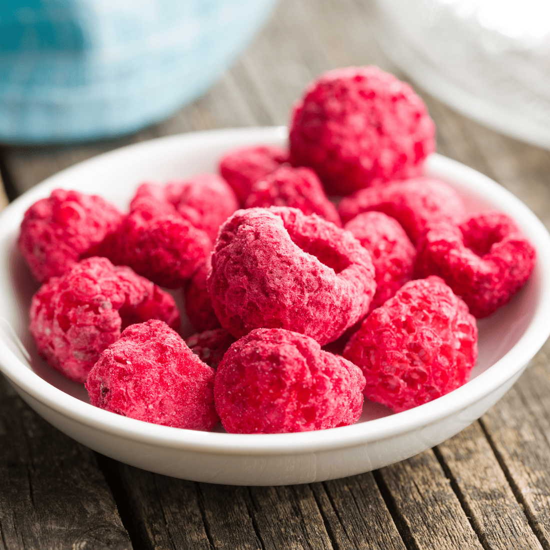  White bowl filled with freeze-dried raspberries.