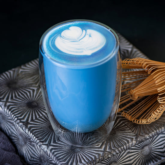 A blue matcha latte with beautiful latte art made with a blue matcha single serve sachet. 