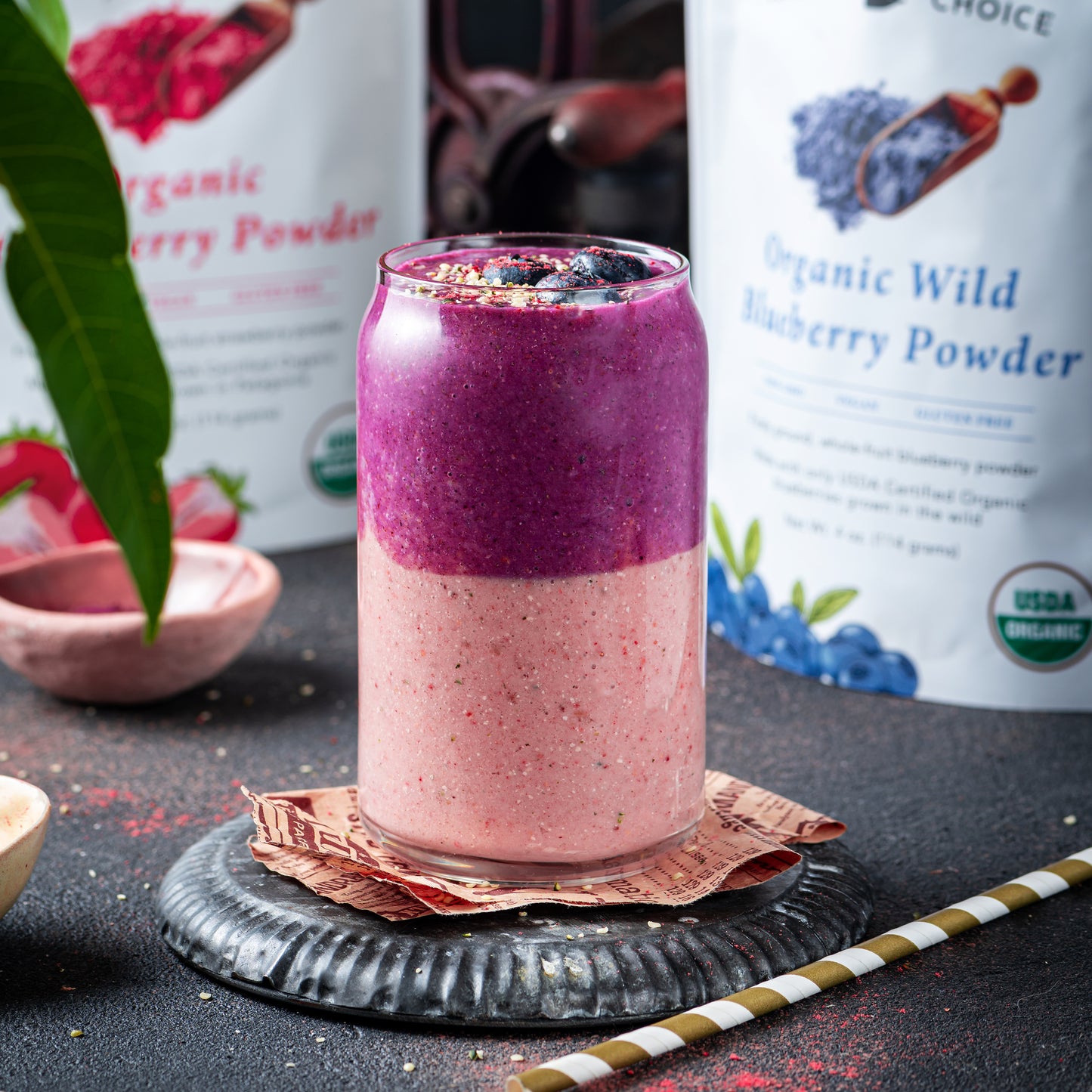 Layered smoothie made with Ancient Choice Strawberry Powder and Ancient Choice Wild Blueberry Powder, topped with berries and granola, served in a glass jar.